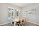 Cozy dining area with a wooden table, shuttered windows, and beach themed wall art at 3517 Big Sky Way, Bradenton, FL 34211