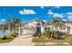 Charming single-story home with a well-manicured lawn, two-car garage, and beautiful landscaping featuring palm trees at 3831 Creekside Park Dr, Parrish, FL 34219