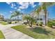 Inviting front yard with a well-manicured lawn, palm trees, and a charming home exterior at 3831 Creekside Park Dr, Parrish, FL 34219