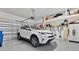 Organized garage featuring a white car, storage shelving, and a functional garage door opener at 3831 Creekside Park Dr, Parrish, FL 34219
