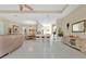 Open-concept living room featuring neutral tones, tile flooring, a kitchen bar, and ample space for entertaining at 3831 Creekside Park Dr, Parrish, FL 34219