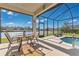 This screened-in patio area offers relaxing lounge and dining spaces and beautiful lake views at 3831 Creekside Park Dr, Parrish, FL 34219