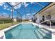Enjoy this screened in backyard pool with an umbrella table set, lush lawn, and manicured hedges at 3831 Creekside Park Dr, Parrish, FL 34219
