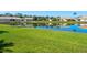 Scenic view of a tranquil pond reflecting nearby homes, surrounded by a lush green lawn at 4155 Cascade Falls Dr, Sarasota, FL 34243