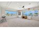 Spacious bedroom with big windows showcasing water views, carpeted floors, and a ceiling fan at 585 Cutter Ln, Longboat Key, FL 34228