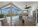 Outdoor seating near a screened-in pool with a waterfront view, and a tropical landscape at 585 Cutter Ln, Longboat Key, FL 34228