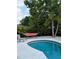 Outdoor pool with hammock and lounge seating surrounded by tropical landscaping at 5876 Countrywood Dr, Sarasota, FL 34232