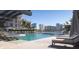 Resort-style pool with hot tub, lounge chairs, and umbrellas, set against a cityscape backdrop at 590 Golden Gate Point # 506, Sarasota, FL 34236