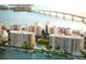 Stunning aerial view of waterfront condos with boat docks, pool, and picturesque bridge in the background at 590 Golden Gate Point # 905, Sarasota, FL 34236