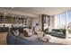 Bright, open-concept living room and kitchen with hardwood floors and floor-to-ceiling windows overlooking the city at 590 Golden Gate Point # 905, Sarasota, FL 34236