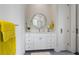 Bathroom boasts a white vanity with round mirror and modern fixtures and access to the lavatory at 624 N Point Dr, Holmes Beach, FL 34217