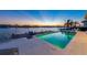 A view of the pool and patio overlooking the serene ocean waters at sunset at 624 N Point Dr, Holmes Beach, FL 34217