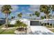 Inviting single-story home featuring a carport, lush lawn, and attractive landscaping with surrounding palm trees at 8449 Imperial Cir, Palmetto, FL 34221