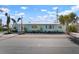 Charming turquoise beach house with landscaped front yard and tropical palm trees at 912 N Shore Dr, Anna Maria, FL 34216