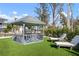 Relaxing gazebo with outdoor seating, lounge chairs and lush landscaping at 912 N Shore Dr, Anna Maria, FL 34216