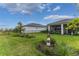 A serene backyard featuring a lawn, landscaping, screened lanai and decorative lighthouse figure at 9978 Bright Water Drive, Englewood, FL 34223