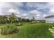 Well maintained backyard with green grass, landscaping, and black metal fencing at 9978 Bright Water Drive, Englewood, FL 34223