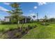 Lush backyard with manicured lawn, well-maintained landscaping, and an inviting screened lanai for outdoor enjoyment at 9978 Bright Water Drive, Englewood, FL 34223