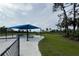 Community park under blue shade canopy featuring picnic tables and open grass at 9978 Bright Water Drive, Englewood, FL 34223