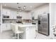 Modern kitchen features white cabinets, stainless steel appliances, quartz countertops, and tile floors at 9978 Bright Water Drive, Englewood, FL 34223