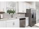 Well-lit kitchen features stainless steel appliances, white cabinets, granite countertops, and tile floors at 9978 Bright Water Drive, Englewood, FL 34223