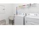Clean laundry room with modern washer and dryer, utility sink, and convenient storage shelves at 9978 Bright Water Drive, Englewood, FL 34223