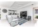 Open living room features tile floor, large windows, modern furniture, and tray ceiling at 9978 Bright Water Drive, Englewood, FL 34223