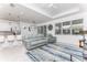 Bright living room with tile floors, large windows, modern furniture, and recessed lighting at 9978 Bright Water Drive, Englewood, FL 34223