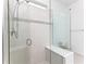 Modern tiled shower with a glass enclosure, built-in bench, and sleek fixtures creates a spa-like experience at 9978 Bright Water Drive, Englewood, FL 34223