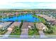 Beautiful aerial view of homes surrounding a lake, complemented by lush landscaping and clear blue skies at 16741 Ellsworth Ave, Bradenton, FL 34202