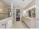Bright bathroom with dual sinks, vanity, tiled shower and floors, adjacent to a bedroom space at 16741 Ellsworth Ave, Bradenton, FL 34202