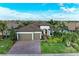Beautiful single-Gathering home with a three-car garage, tile roof, brick driveway, and lush tropical landscaping at 16741 Ellsworth Ave, Bradenton, FL 34202