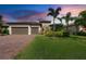 Charming single-story home with a three-car garage, lush lawn, and tropical landscaping at 16741 Ellsworth Ave, Bradenton, FL 34202