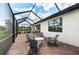 Screened patio with four chairs and round table on a brick patio at 16741 Ellsworth Ave, Bradenton, FL 34202