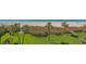 Beautiful green backyard featuring lush lawn, tall palm trees, and a view of the ocean at 2675 Gulf Of Mexico Dr # 301, Longboat Key, FL 34228