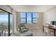 Bedroom with ocean view windows, chair with ottoman, and desk with computer at 2675 Gulf Of Mexico Dr # 301, Longboat Key, FL 34228