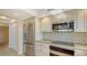 Updated kitchen with stainless steel refrigerator, microwave, and mosaic tile backsplash at 2675 Gulf Of Mexico Dr # 301, Longboat Key, FL 34228