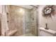 Neutral tiled walk-in shower with glass doors, seating, and wall niche for storage at 2675 Gulf Of Mexico Dr # 301, Longboat Key, FL 34228