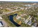 Aerial view of houses, surrounding greenery, and beautiful neighborhood pond at 28 Tall Trees Ct, Sarasota, FL 34232