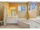 Bright bathroom featuring a soaking tub, double vanity, and a separate toilet room at 28 Tall Trees Ct, Sarasota, FL 34232