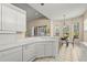 Bright kitchen features white cabinetry, tile floors, and a cozy breakfast nook overlooking the yard at 28 Tall Trees Ct, Sarasota, FL 34232
