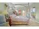 A serene main bedroom features a unique four-poster bed and access to a screened patio at 28 Tall Trees Ct, Sarasota, FL 34232