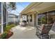 Screened patio with ceiling fan, outdoor seating area, and sliding glass doors to the interior at 28 Tall Trees Ct, Sarasota, FL 34232