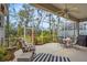 A screened-in patio features a dining set and lounge furniture, surrounded by lush landscaping at 28 Tall Trees Ct, Sarasota, FL 34232