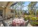 Screened patio with ceiling fan, outdoor seating area, and manicured backyard at 28 Tall Trees Ct, Sarasota, FL 34232