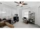 Cozy bedroom featuring a ceiling fan, white curtains, and light stone-colored flooring, with a small desk and shoe rack at 2930 Prospect St, Sarasota, FL 34239