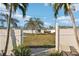 Spacious backyard view through the gate with well maintained lawn and white fencing for privacy at 3000 Holly Ave # 3000, Englewood, FL 34224