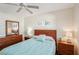 Serene bedroom with wood floors, ceiling fan, a wood bed frame, and calming blue accents at 3000 Holly Ave # 3000, Englewood, FL 34224