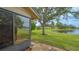 Brick patio overlooks lush green lawn with mature trees and a serene lake backdrop at 3119 Glen Elyn Blvd # 9, Sarasota, FL 34237