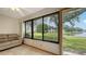Bright sunroom includes a couch and a view of the lake and surrounding greenery at 3119 Glen Elyn Blvd # 9, Sarasota, FL 34237
